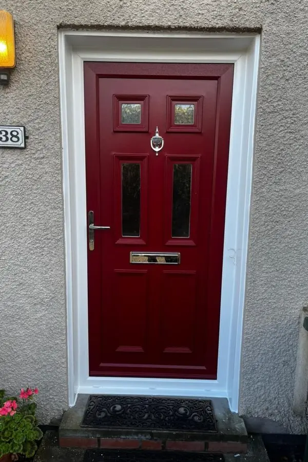 Bright red composite front door with a house number on the panel and a chrome handle