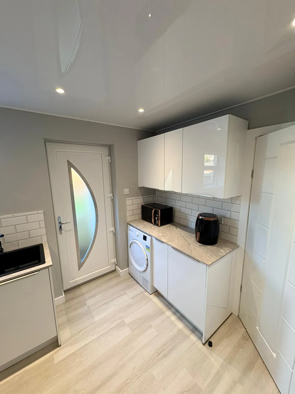 White gloss kitchen with tall larder units by Ultimate Home Solutions