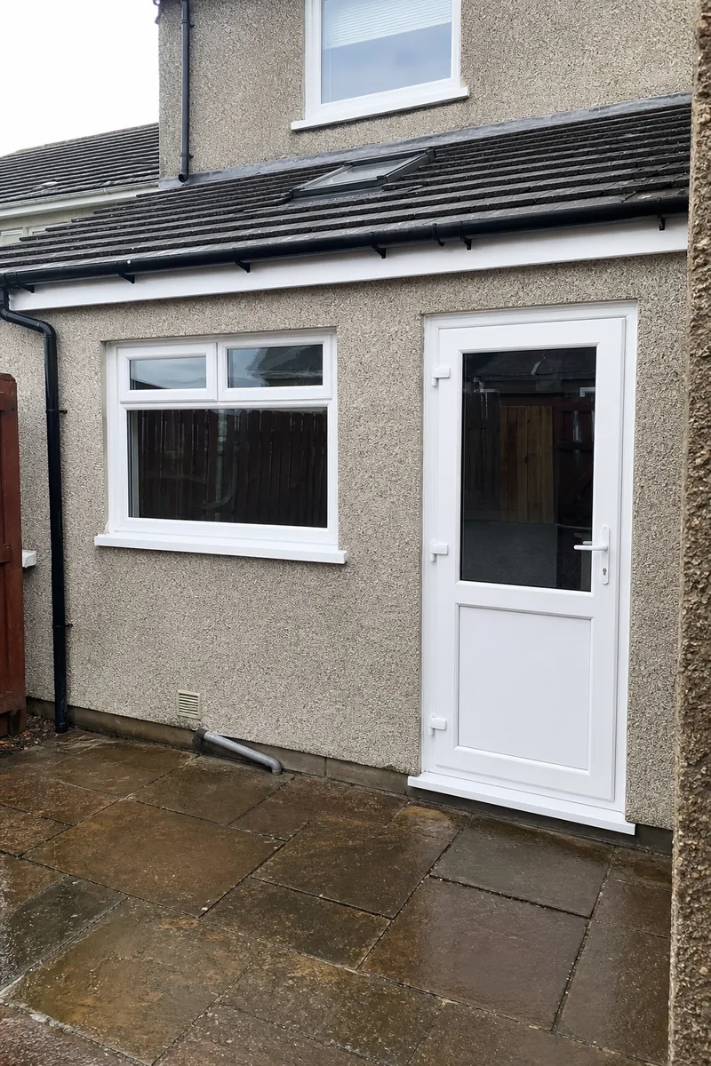 A white uPVC back door with a glazed upper panel, fitted beside a new window on a harled extension